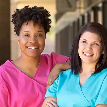 Two skilled nurses smiling together.