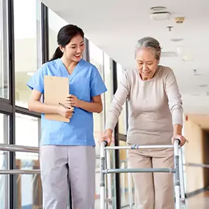 A senior woman using a walker as she discusses fall prevention with her doctor.