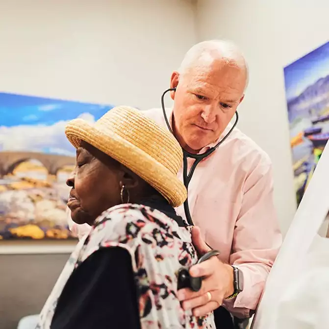 Senior physician, Dr. Steven Mills, treating a senior woman at the SeniorSelect Center.